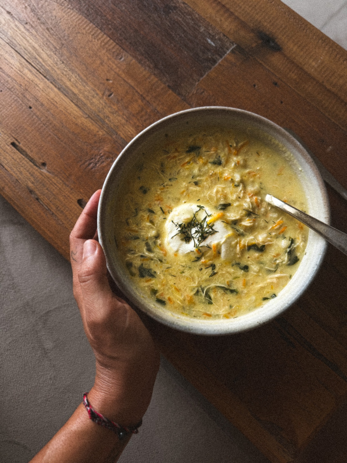 Warming bowl of nourishing soup with herbs and fresh cream